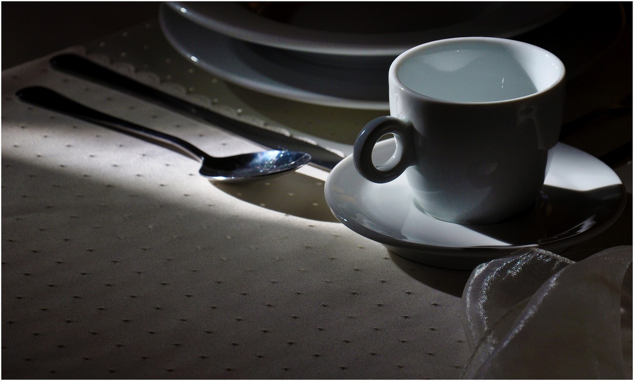 Tovaglia macchiata di caffè con detergente e panno per rimuovere le macchie.