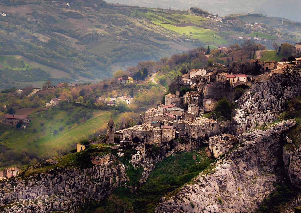 Borgo abruzzese incantevole con case colorate e paesaggio fiabesco.